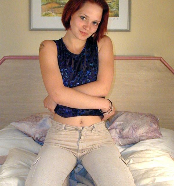 hübsches brünettes Girl kniet auf dem Bett